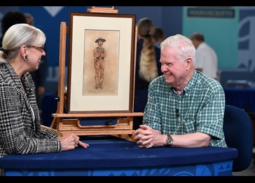 Man and woman at a blue table with an old painting of a person on display image