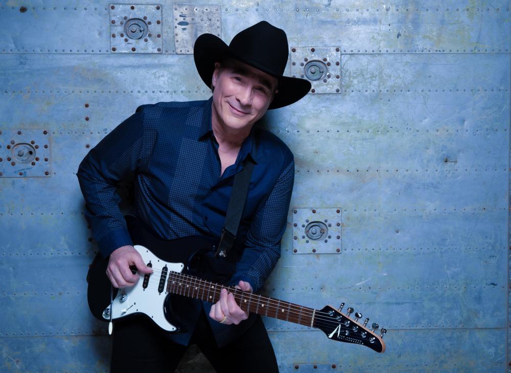 A person playing guitar in a cowboy hat