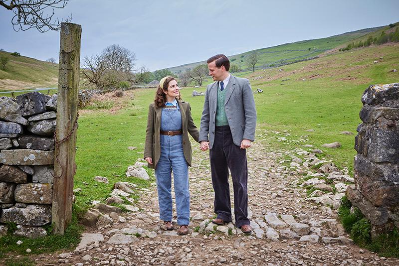 man and woman holding hands on rock path image