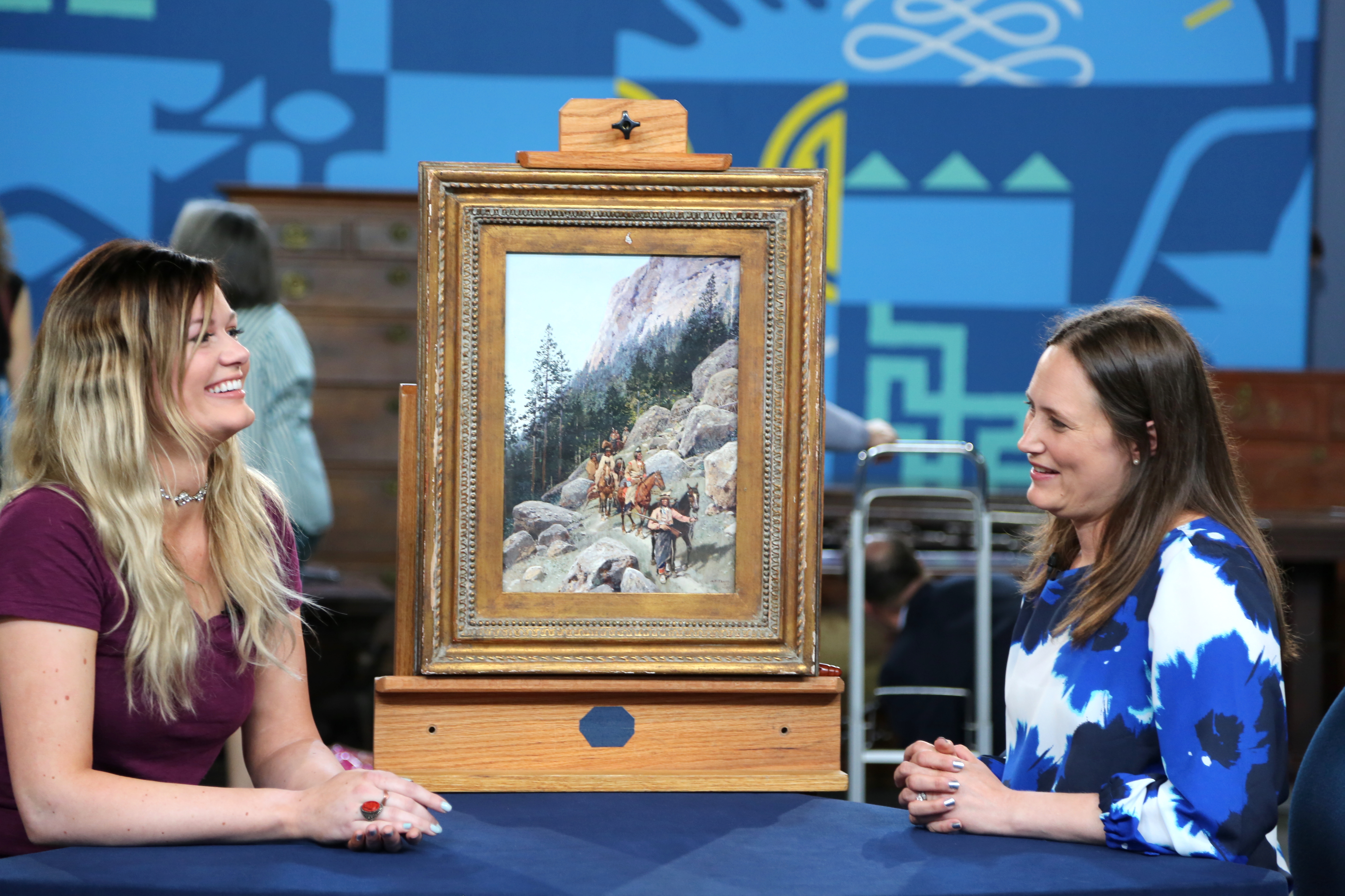 Two women on either side of a painting image
