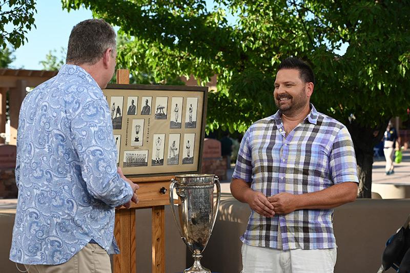 two men outside discussing a trophy image