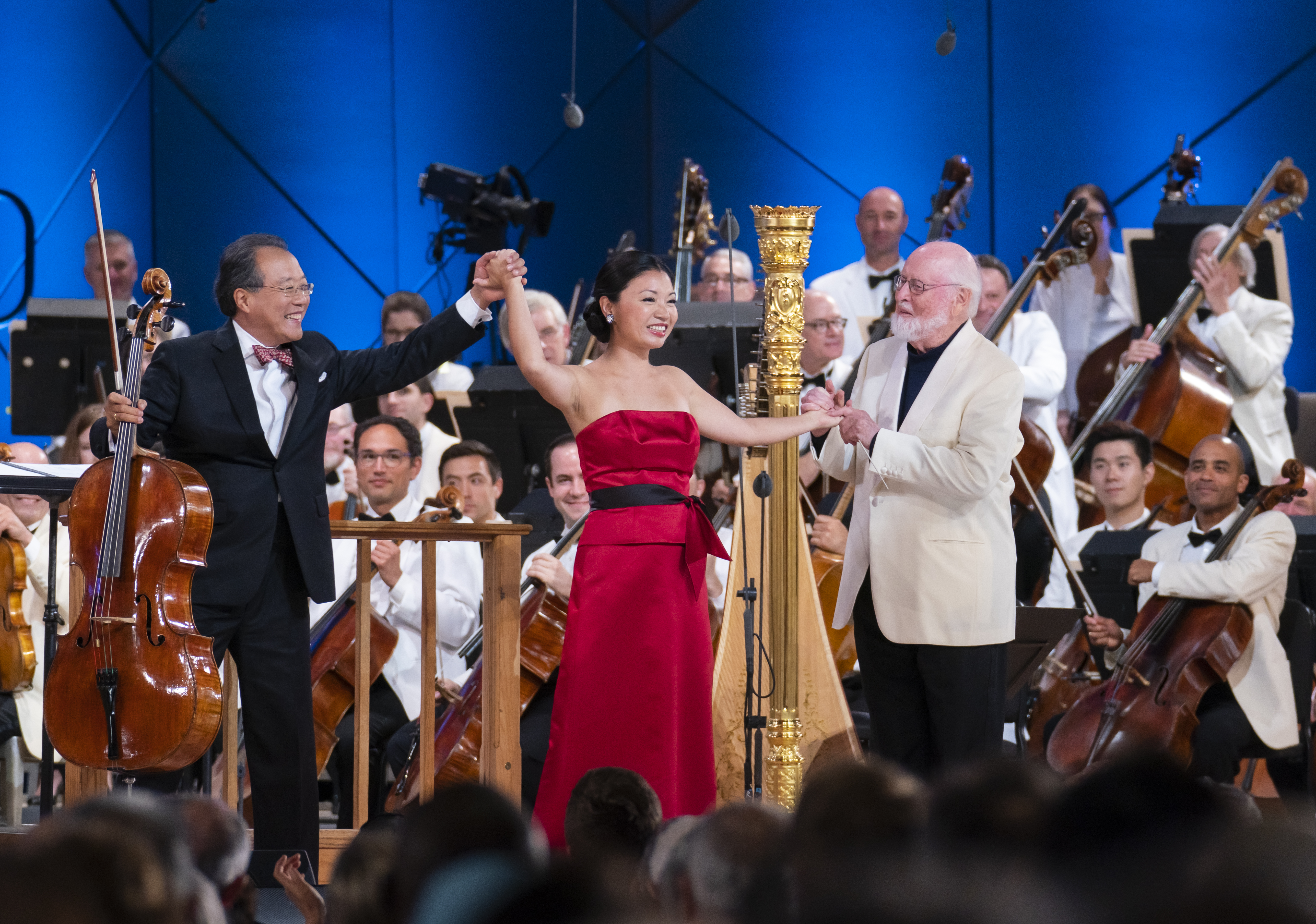 Woman in red dress raising her arm up on stage