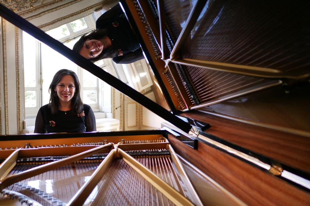 A woman looking inside of a piano