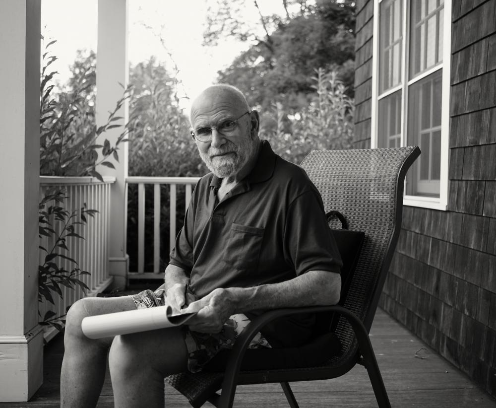 A man sitting on a chair on a front porch