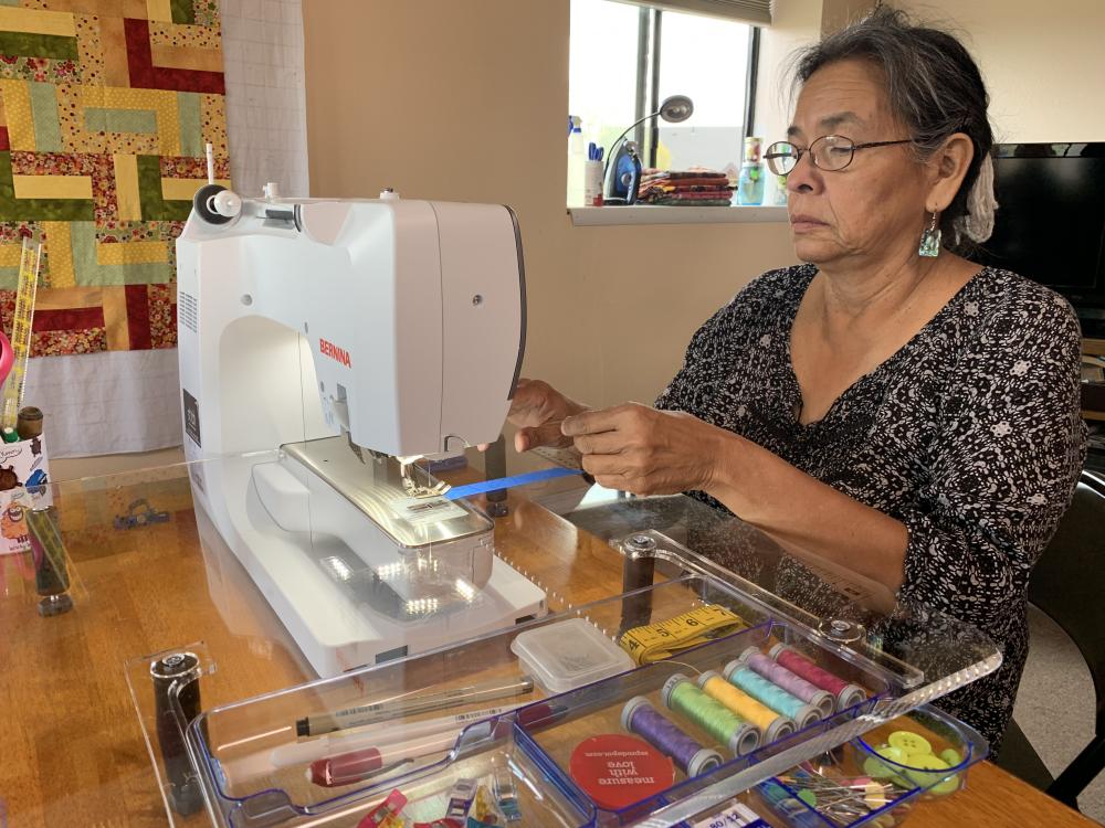 A woman using a sewing machine image