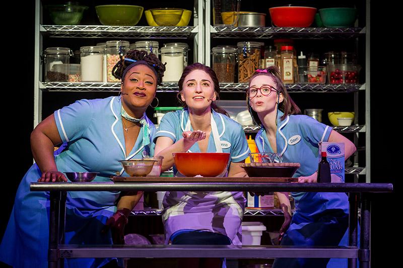 3 actresses on stage wearing baby blue 50s diner uniforms