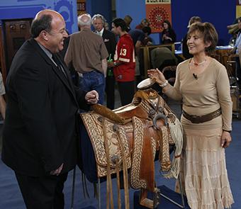 Two people looking at a saddle