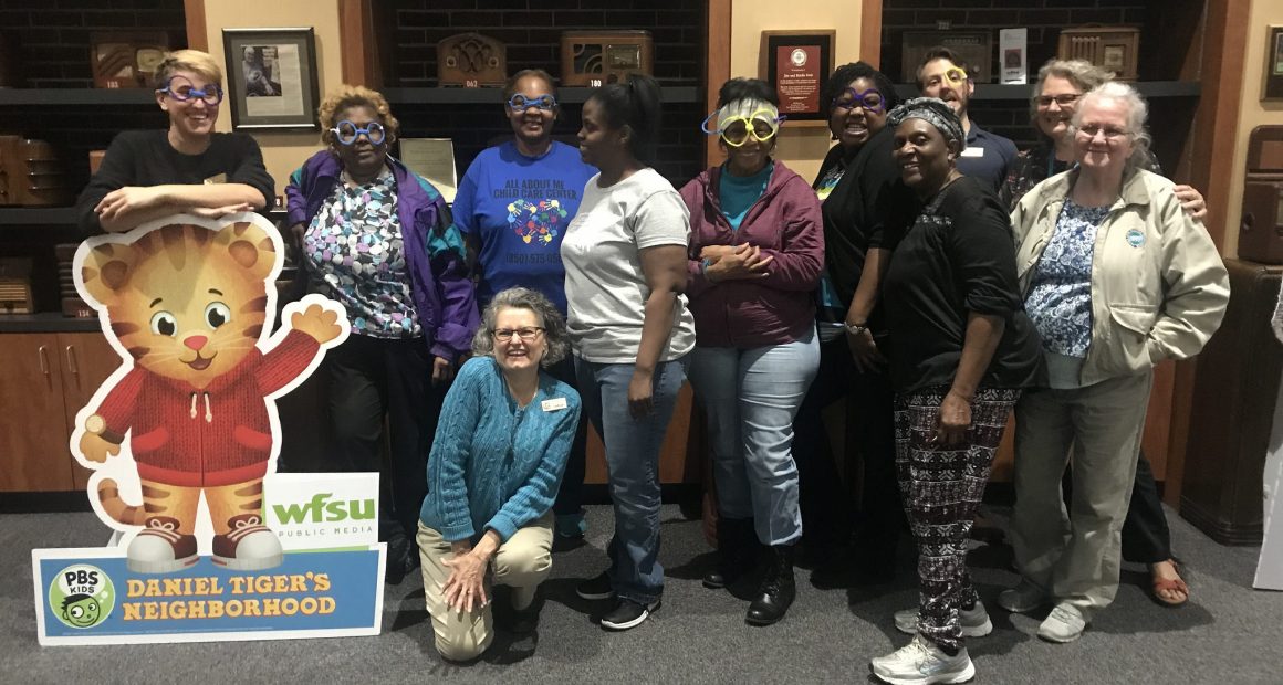 large group of teachers posing in WFSU's lobby with WFSU staff