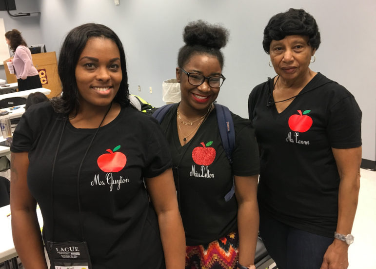 3 women with black shirts bearing apple logo