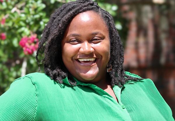 woman in green smiling at camera