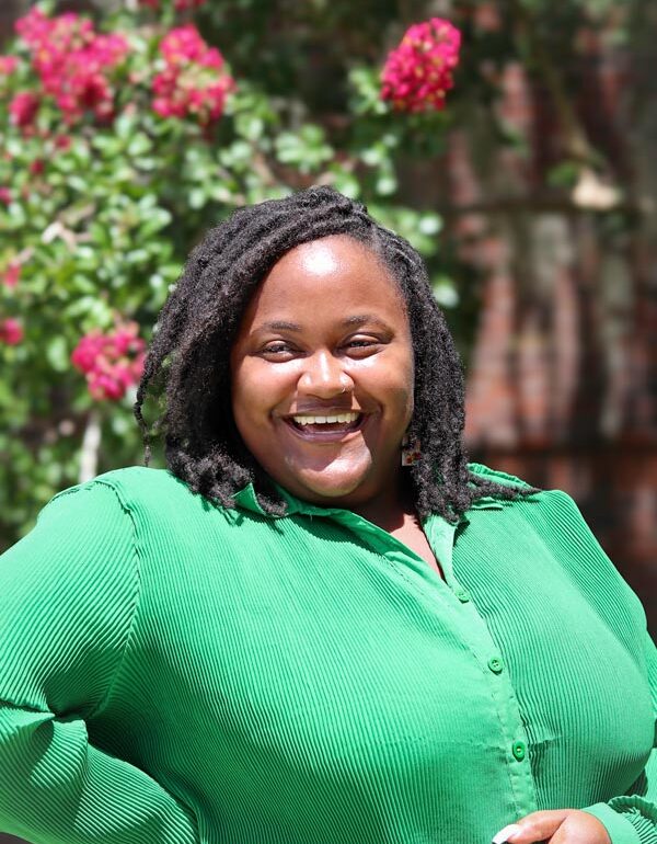 woman in green smiling at camera