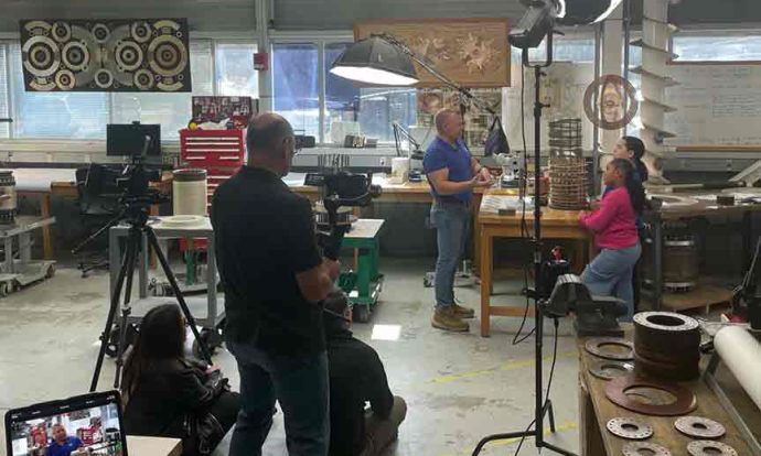 A camera crew is set up in the FSU MagLab with a reporter interviewing individuals at a lab station.
