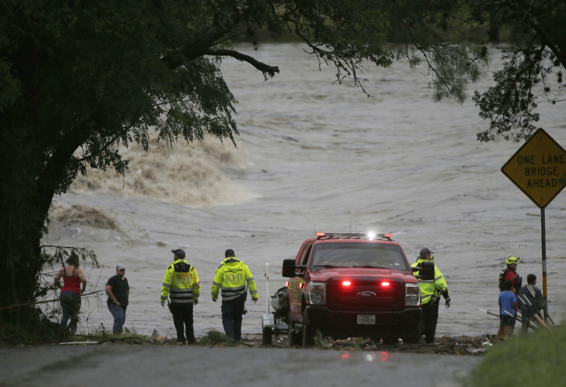 First responders scan the banks of the Guadalupe River for individuals swept away by flooding in Ingram, Texas, on Friday.