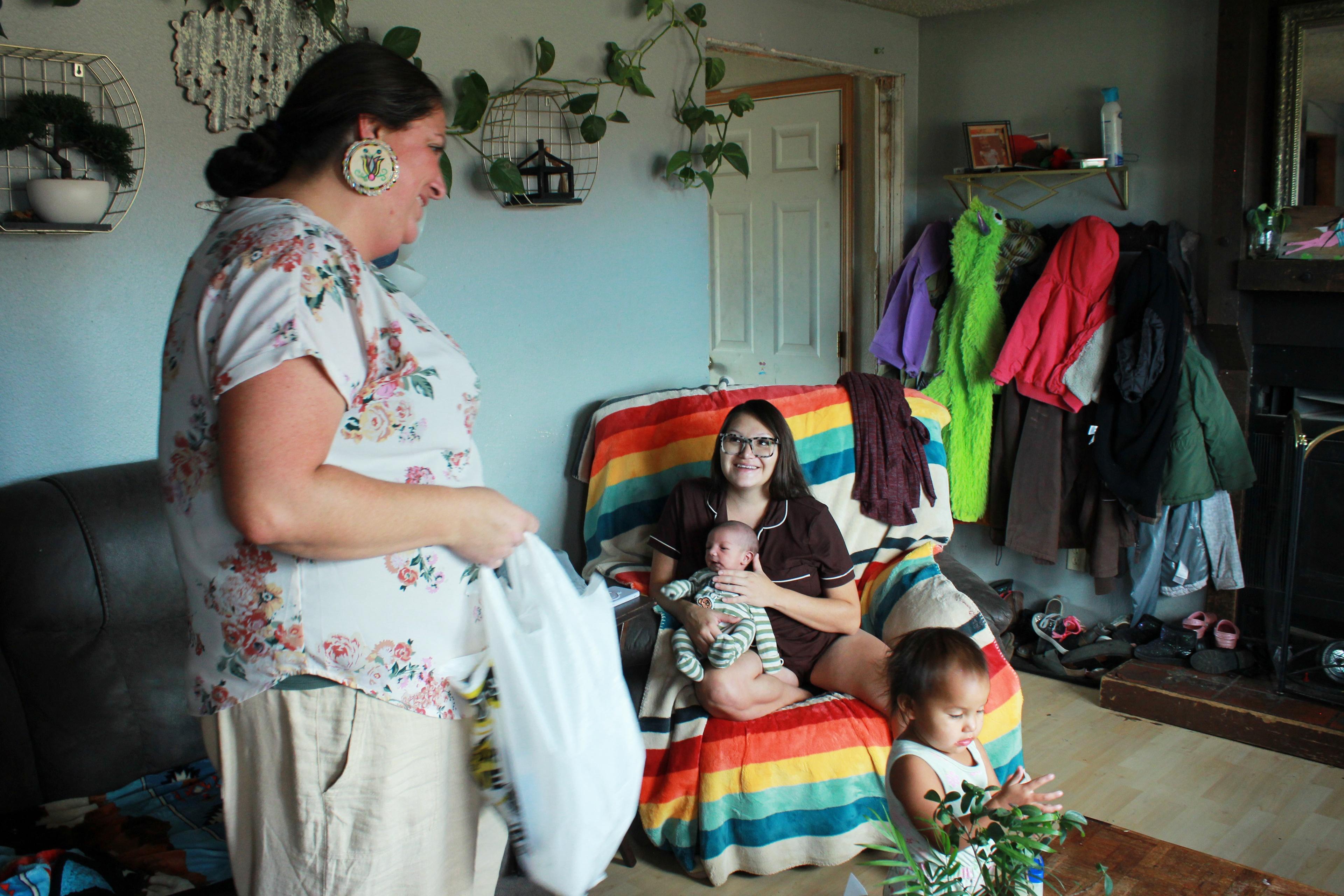 Misty Pipe (left) delivers a care package for a mom she recently supported through pregnancy, Britney WolfVoice. Pipe offers free doula care because Lame Deer â her hometown on the Northern Cheyenne Indian Reservation in Montana â is about 100 miles from the closest hospital that delivers babies.