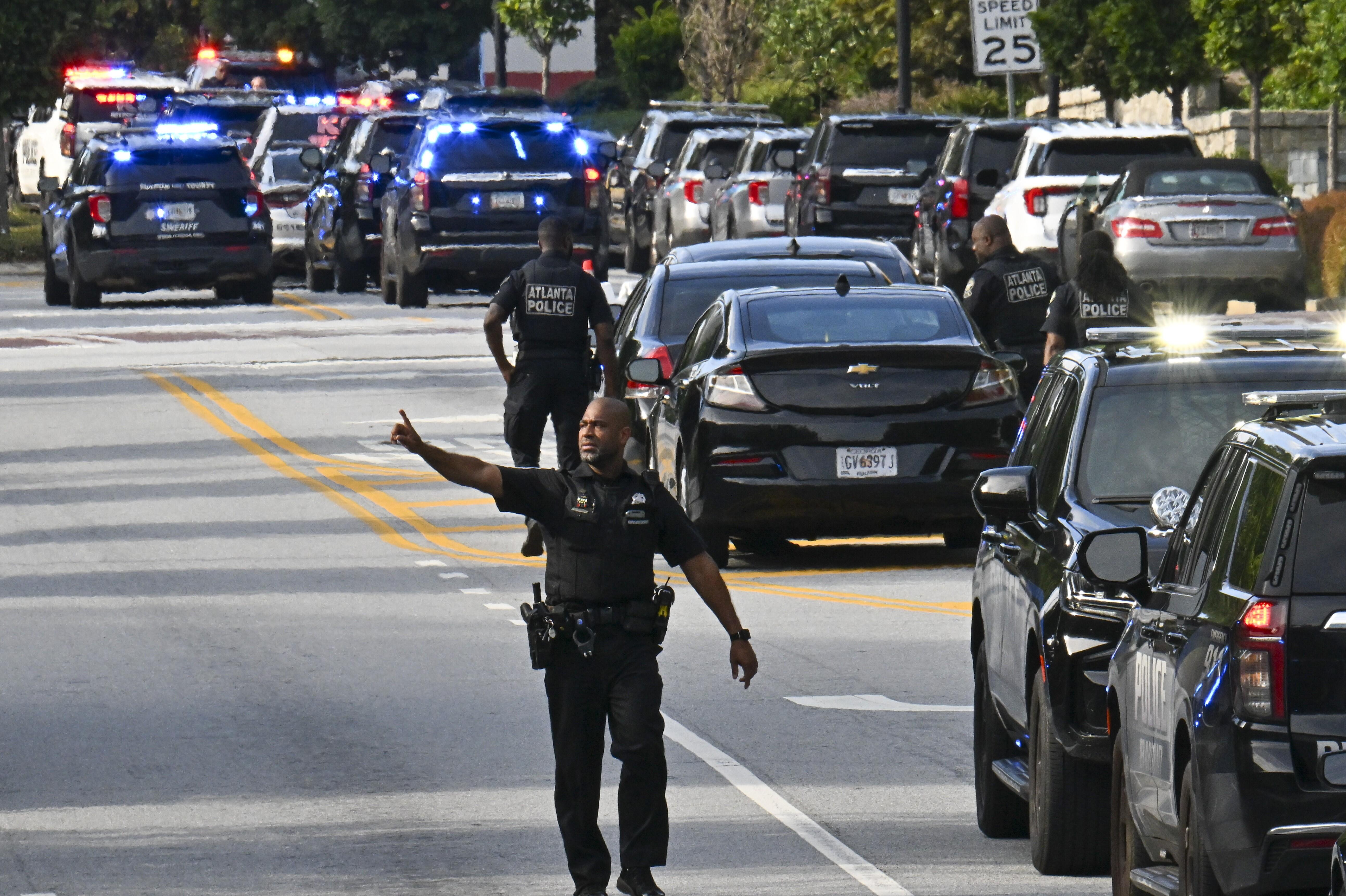 Police officers block Clifton Road near Emory Hospital as they respond to a shooting near the campuses of the U.S. Centers for Disease Control and Prevention and Emory University on Friday.