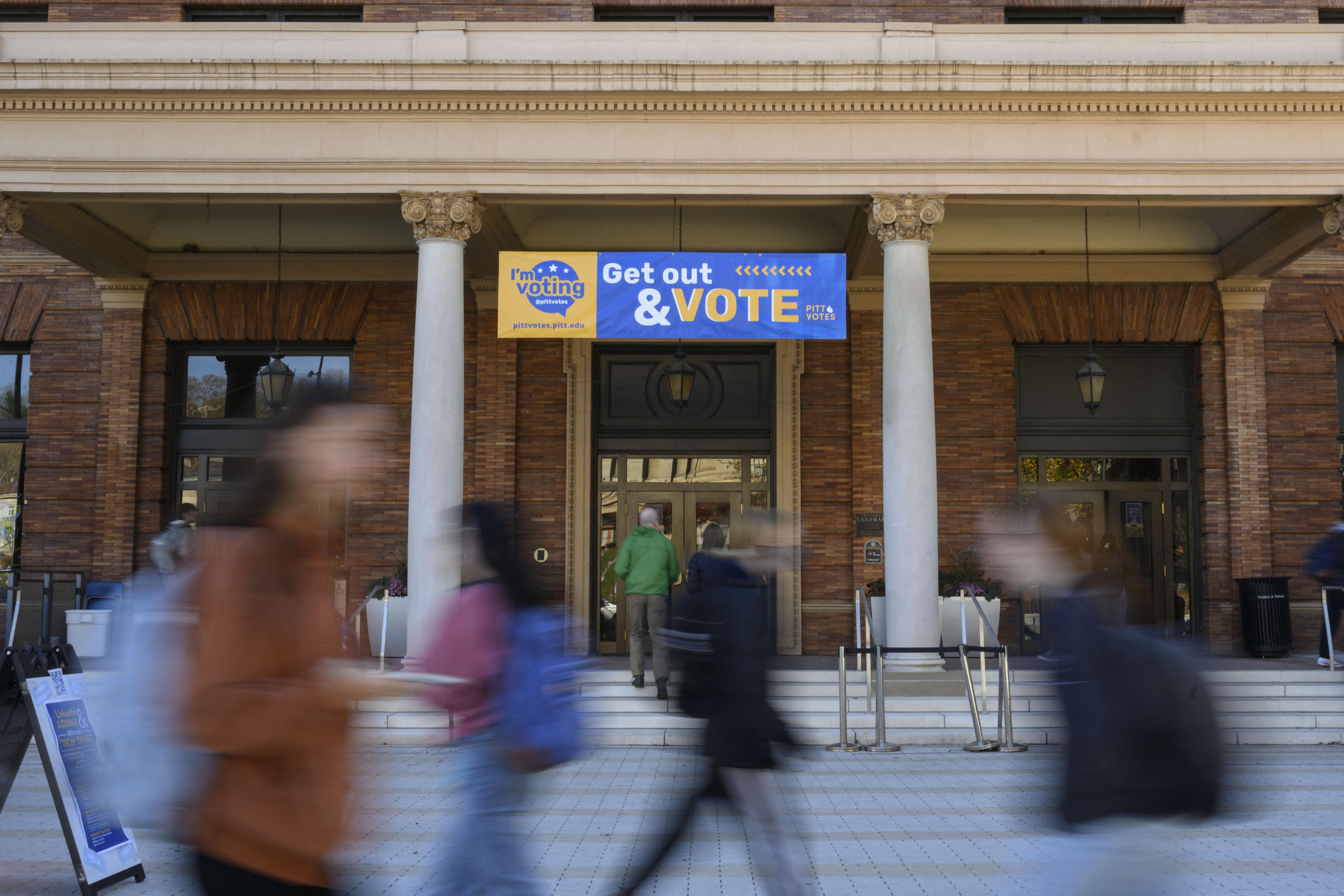 Students walk past a polling site at the University of Pittsburgh during the 2022 midterm election in Pittsburgh, Pa.