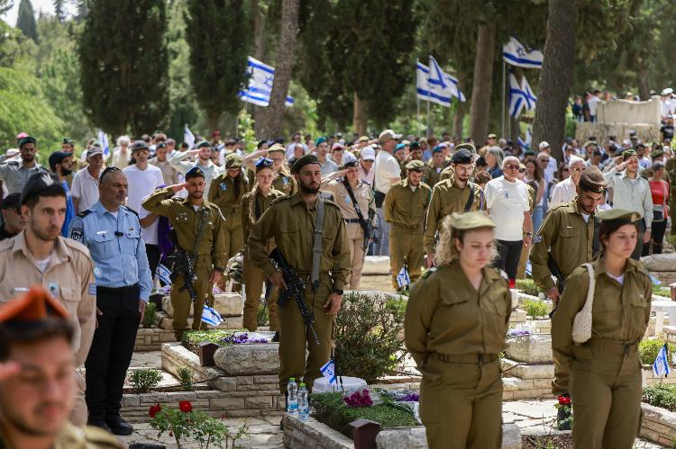 Israeli soldiers and mourners observe two minutes of silence during the Memorial Day commemoration for fallen soldiers, or Yom HaZikaron in Hebrew, at the Mount Herzl military cemetery in Jerusalem on April 30, 2025.