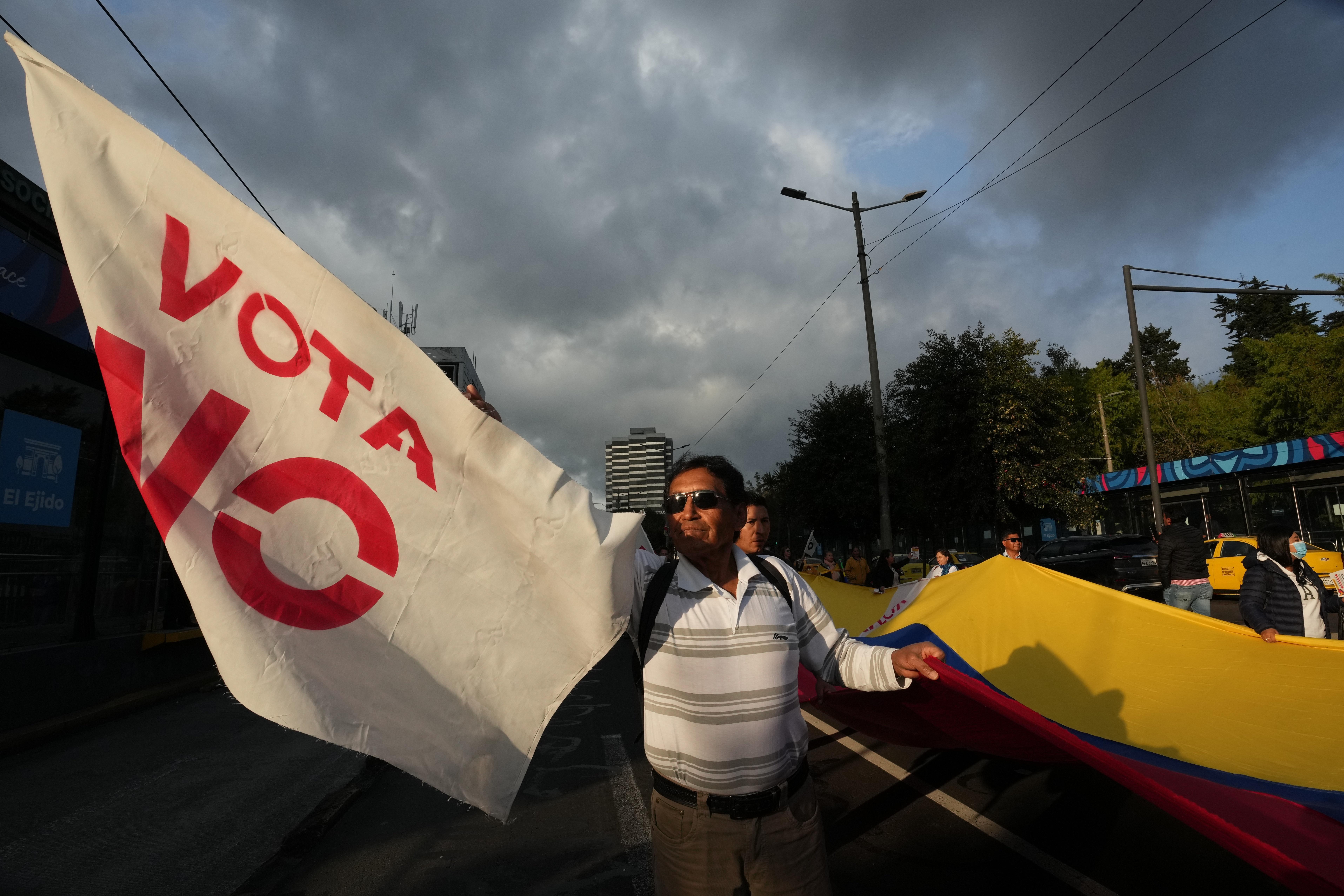 Demonstrators encourage passersby to vote against a referendum to decide, among other items, whether to allow foreign military bases in Ecuador, during a rally in Quito, Wed. Nov. 12, 2025. In the end, the no vote won.