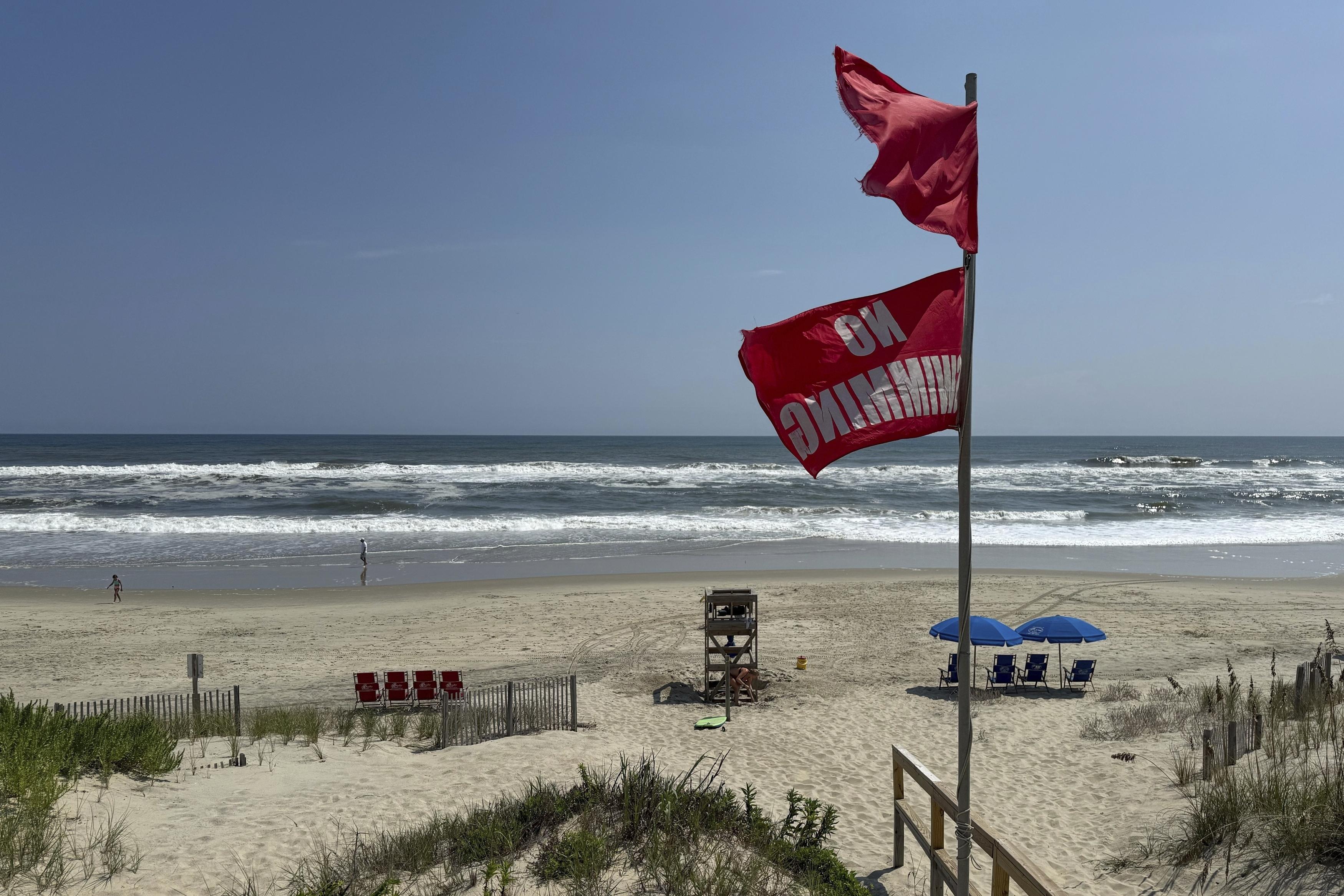 Red flags, indicating swimming is prohibited, are raised at the beach in Duck, N.C., on Tuesday. Forecasters warn of dangerous rip currents along the East Coast.