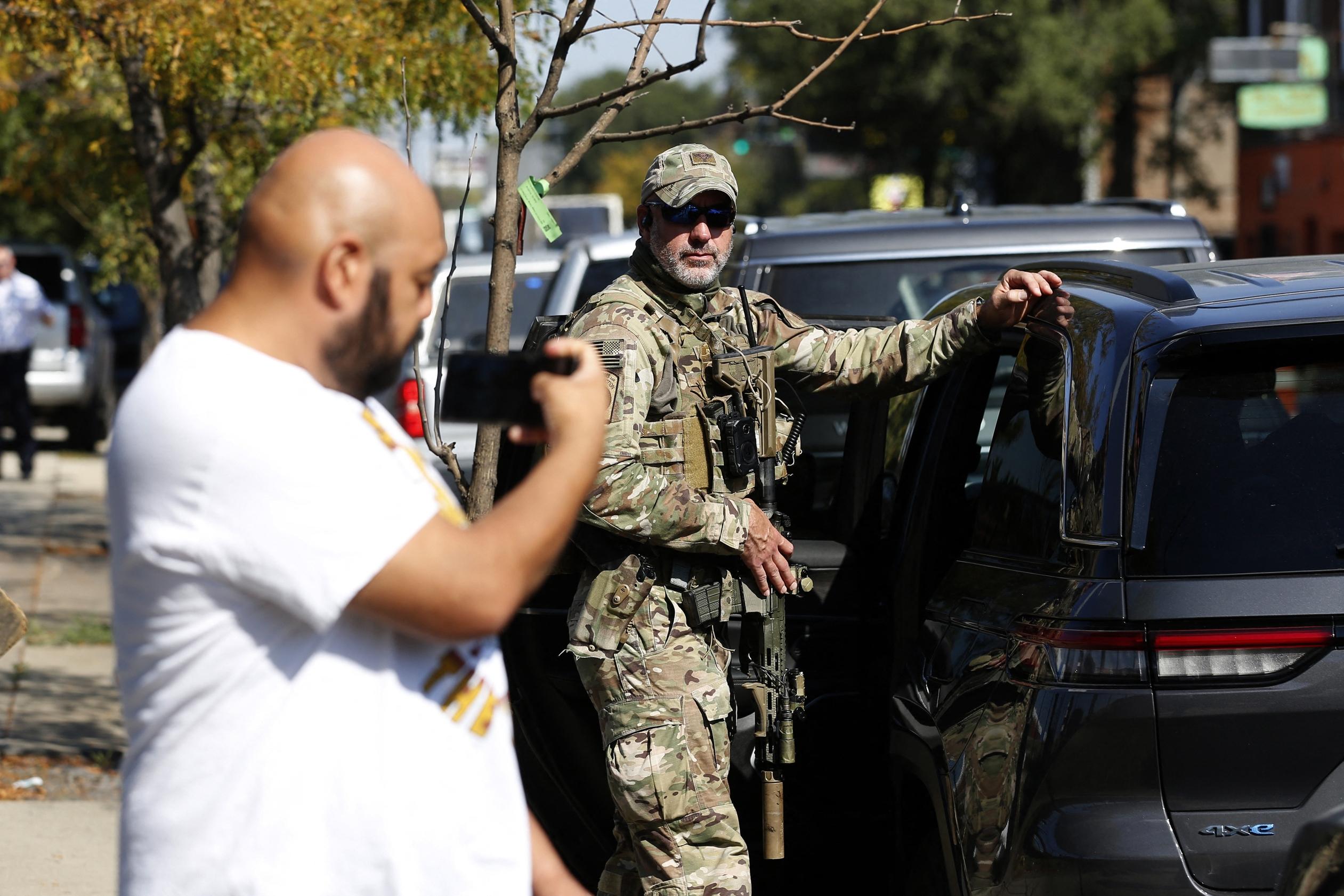 A man holds his phone up next to a U.S. Customs and Border Protection (CBP) Border Patrol agent during an immigration raid in Chicago on Oct. 4, 2025. The top official of CBP