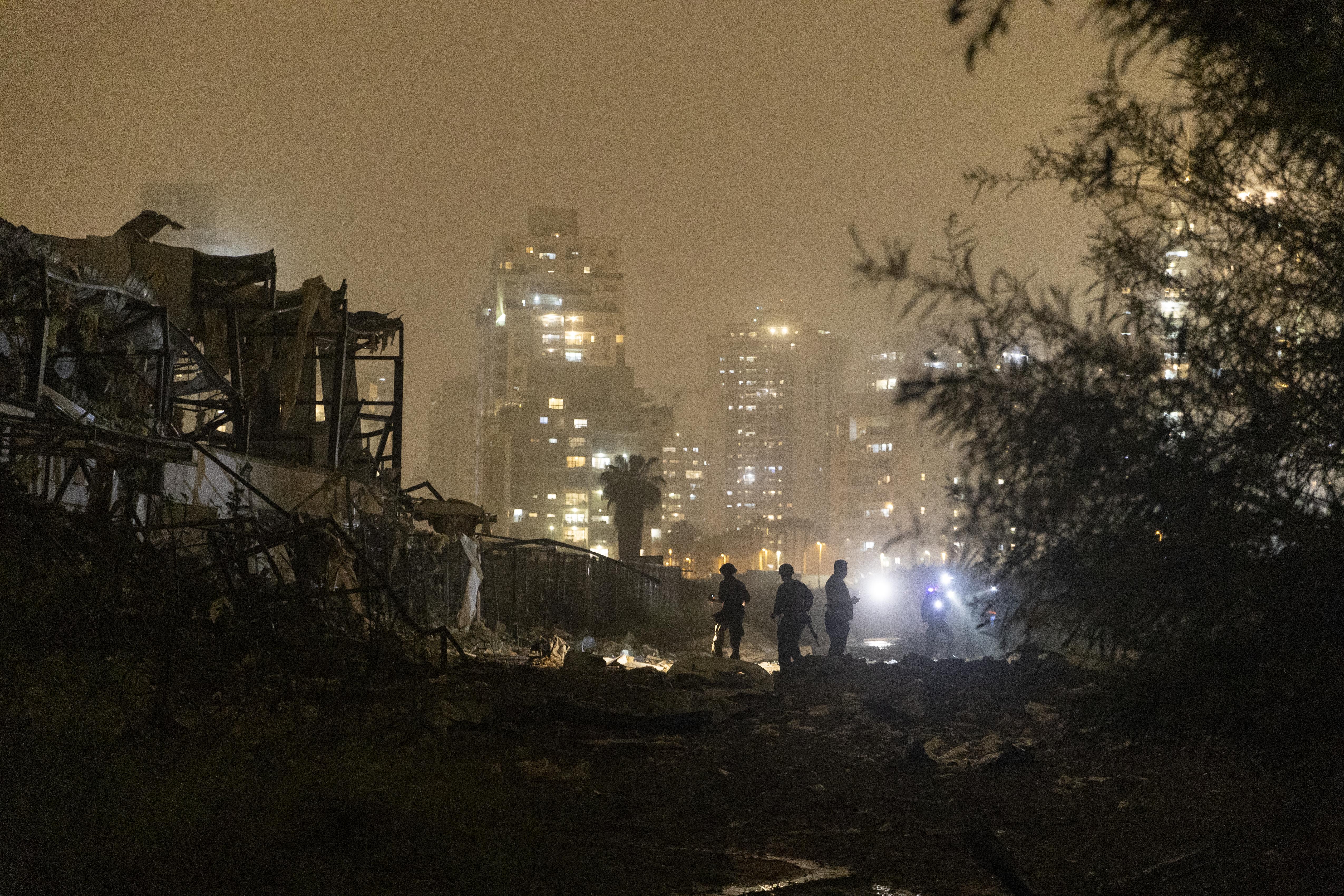Israeli emergency responders inspect a scene of a direct ballistic missile hit, after it was launched from Iran on Thursday, in Petah Tikva, Israel. Iran has continued firing waves of drones and missiles at Israel after the U.S. and Israel launched a joint attack on Iran on Feb. 28.