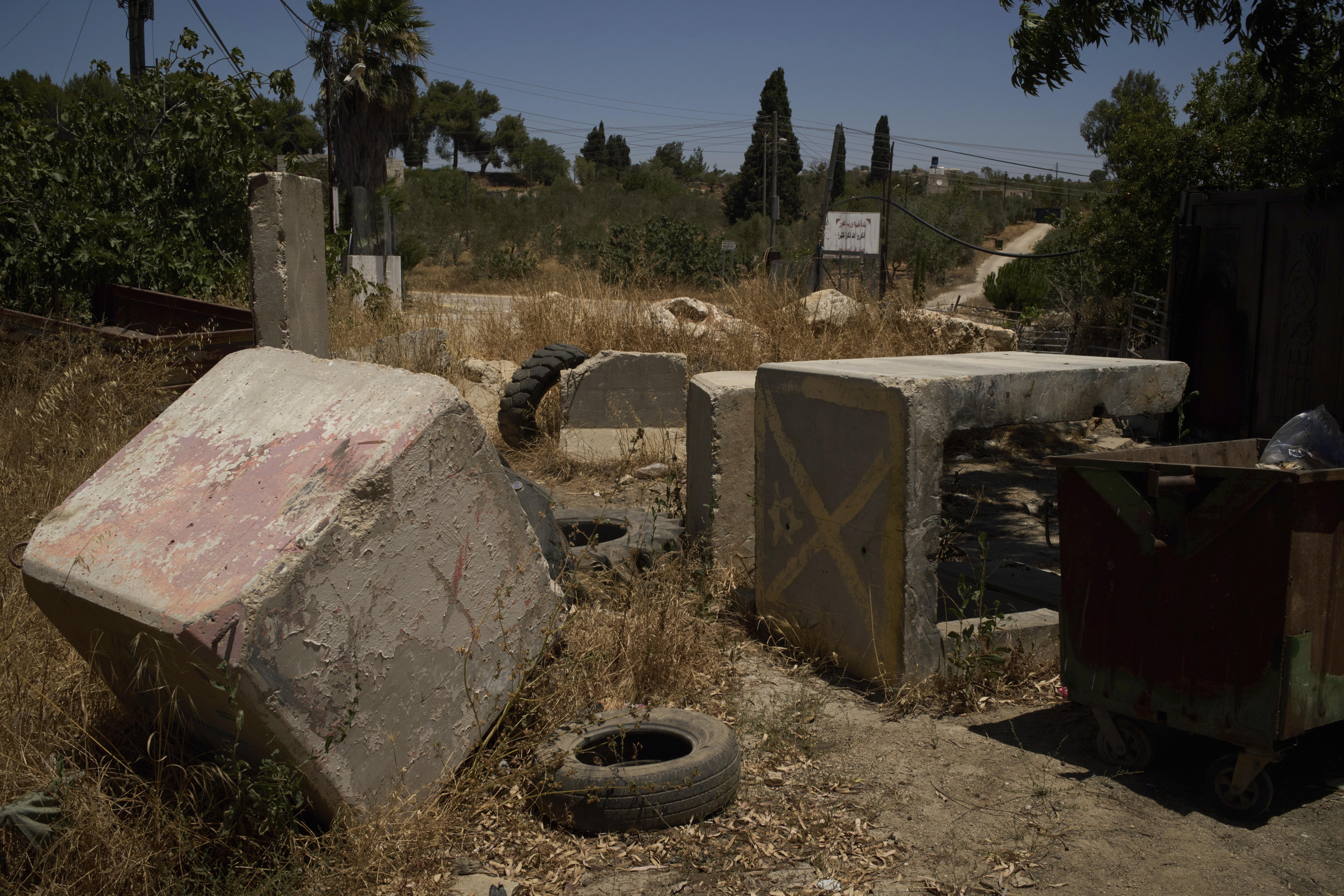 Concrete blocks placed by Israeli soldiers after October 7, 2023, according to local residents, are seen at one of the entrances to the West Bank village of Sinjil, impeding access for Palestinians, on July 9, 2025.