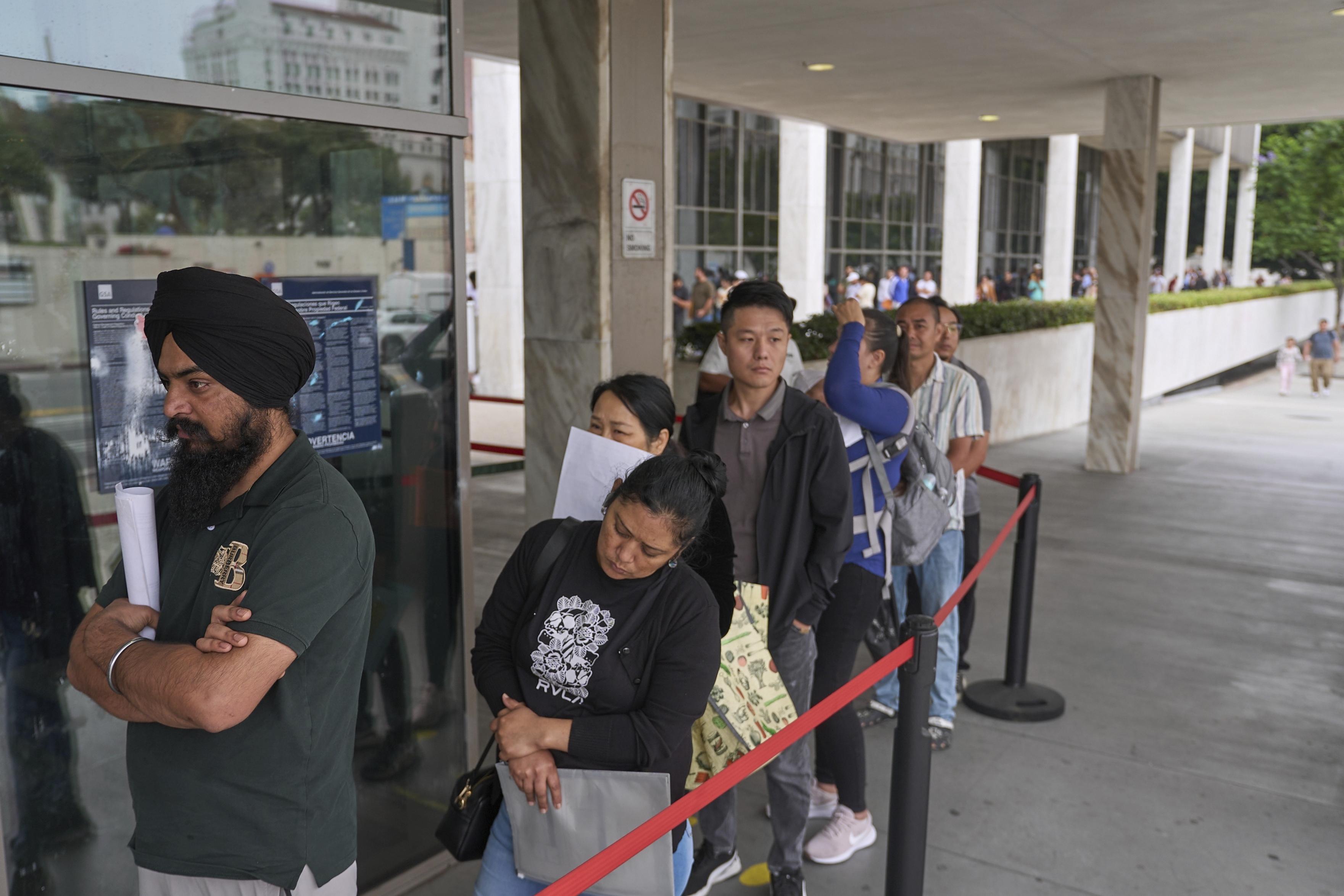 In June 2025, people line up outside the Los Angeles Federal Building, which houses offices for U.S. Immigration and Customs Enforcement and U.S. Citizenship and Immigration Services.