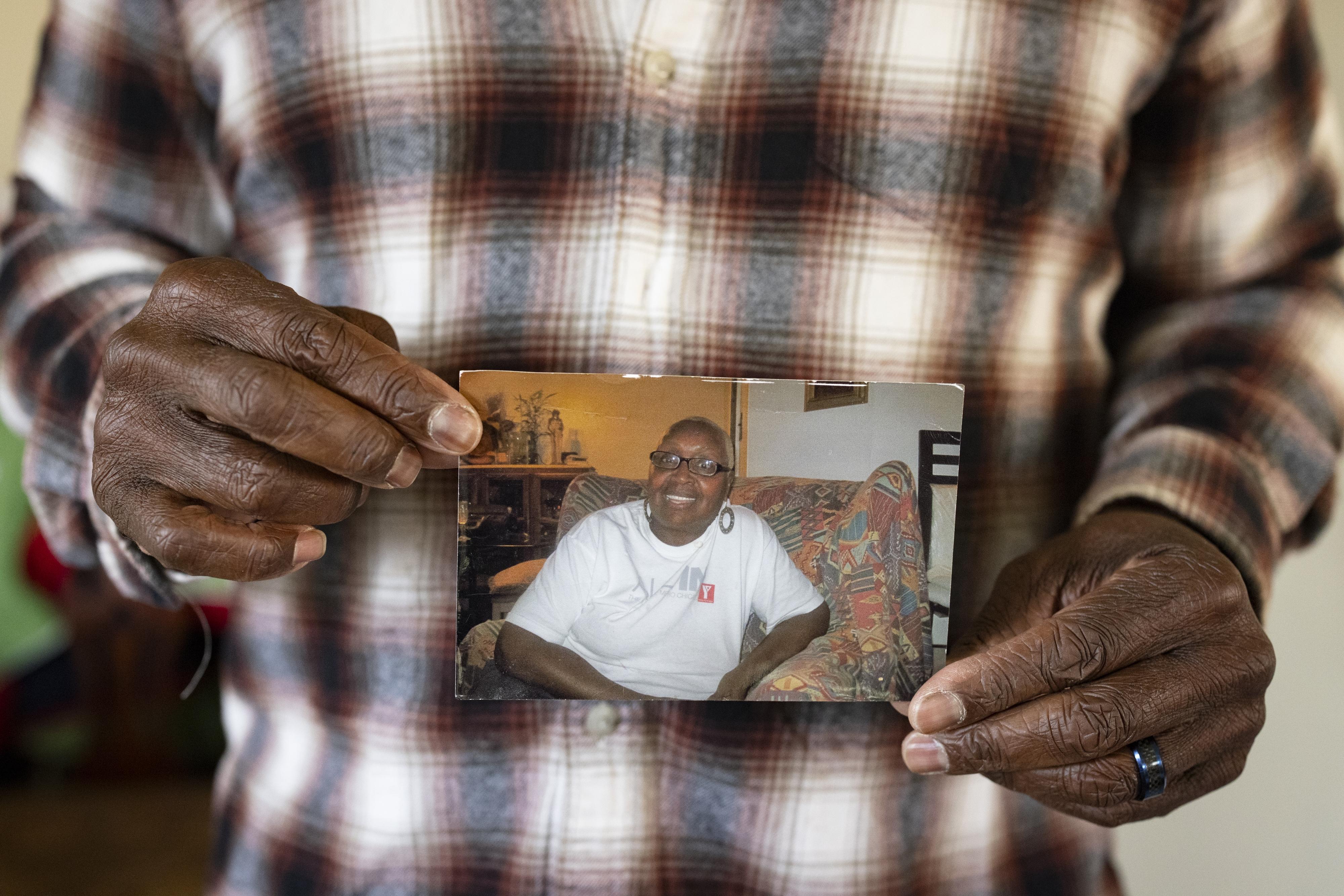 Leslie Adams holds a photo of his mother, Shirley, who died after developing infected bedsores at a rehabilitation center, according to a lawsuit he filed. A court awarded the family $17 million, but they are still trying to collect it.