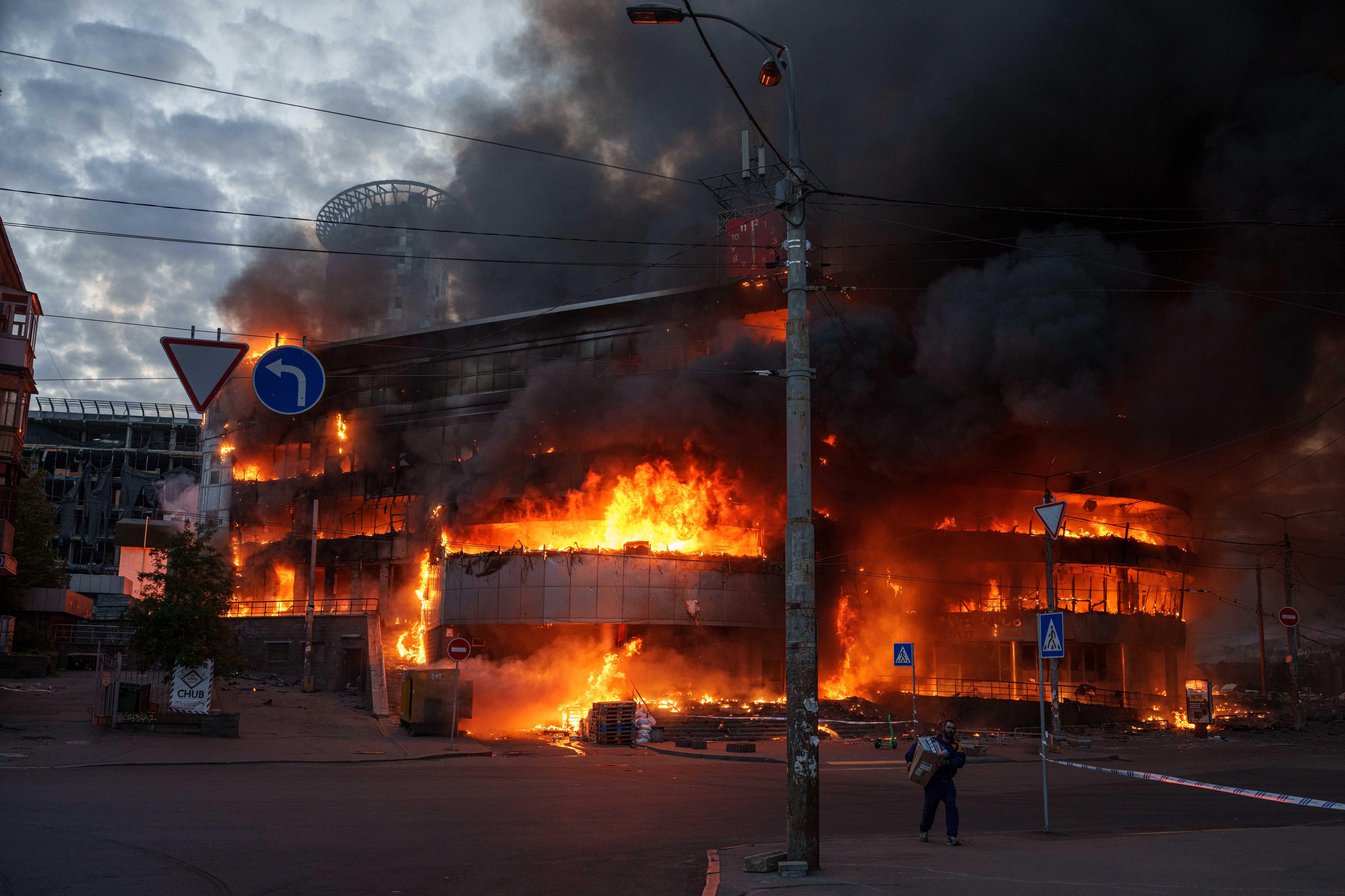 A man carries a box from a burning trade center after a Russian strike on Kyiv, Ukraine, on Sunday, May 24, 2026.