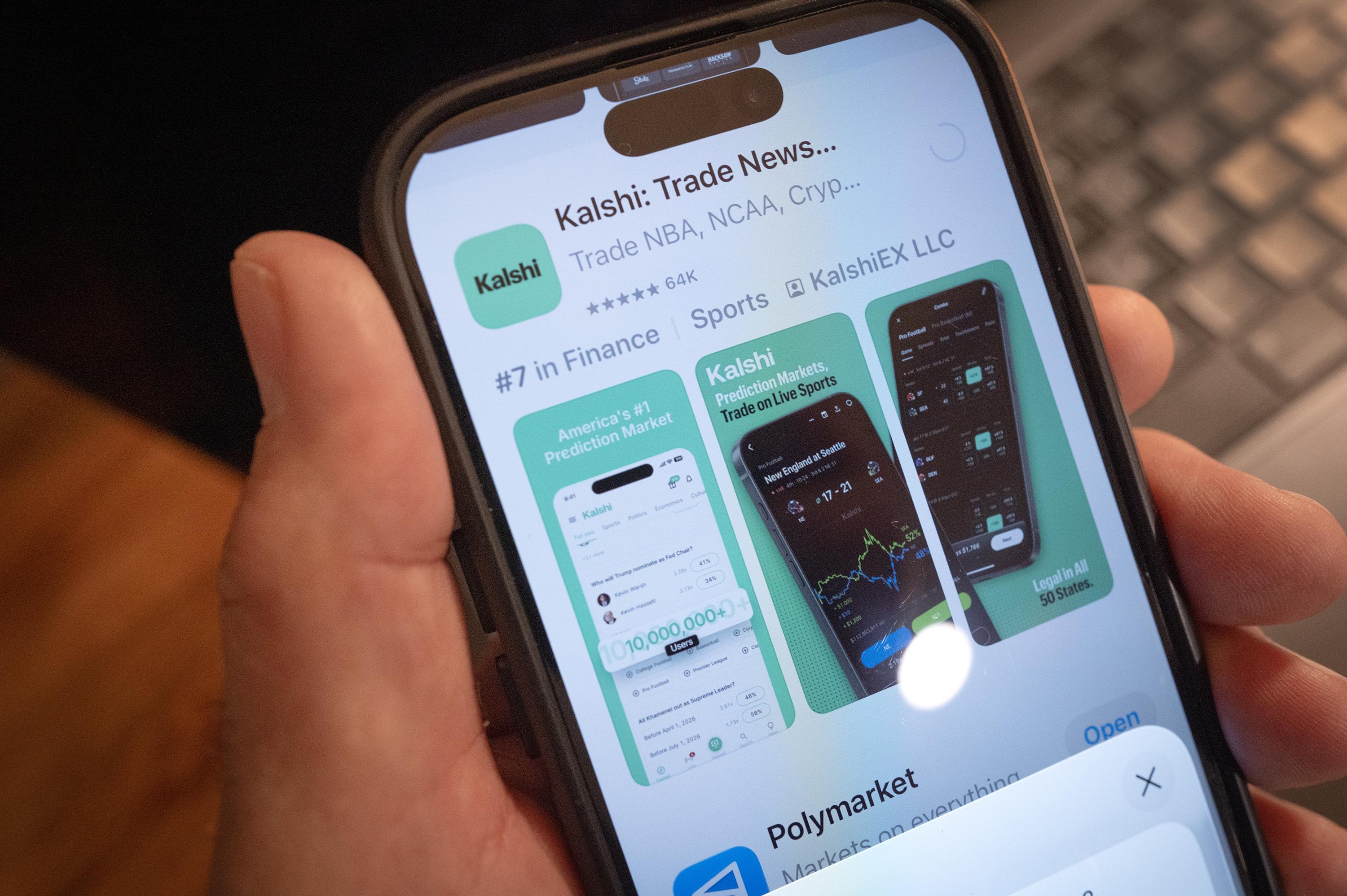 An app for Kalshi, an online prediction market site, is shown on a phone. Multiple states have tried to block the company from operating, citing state gambling laws. But the federal government has sued to block those state laws to allow Kalshi and other prediction markets to operate.