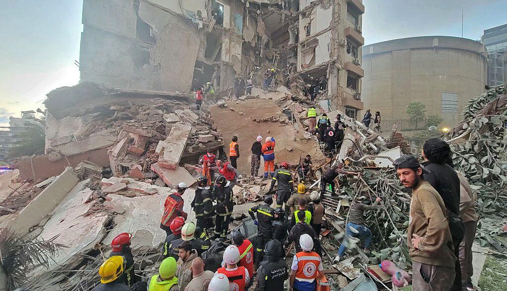 First responders and residents gather at the site of an Israeli airstrike in Beirut