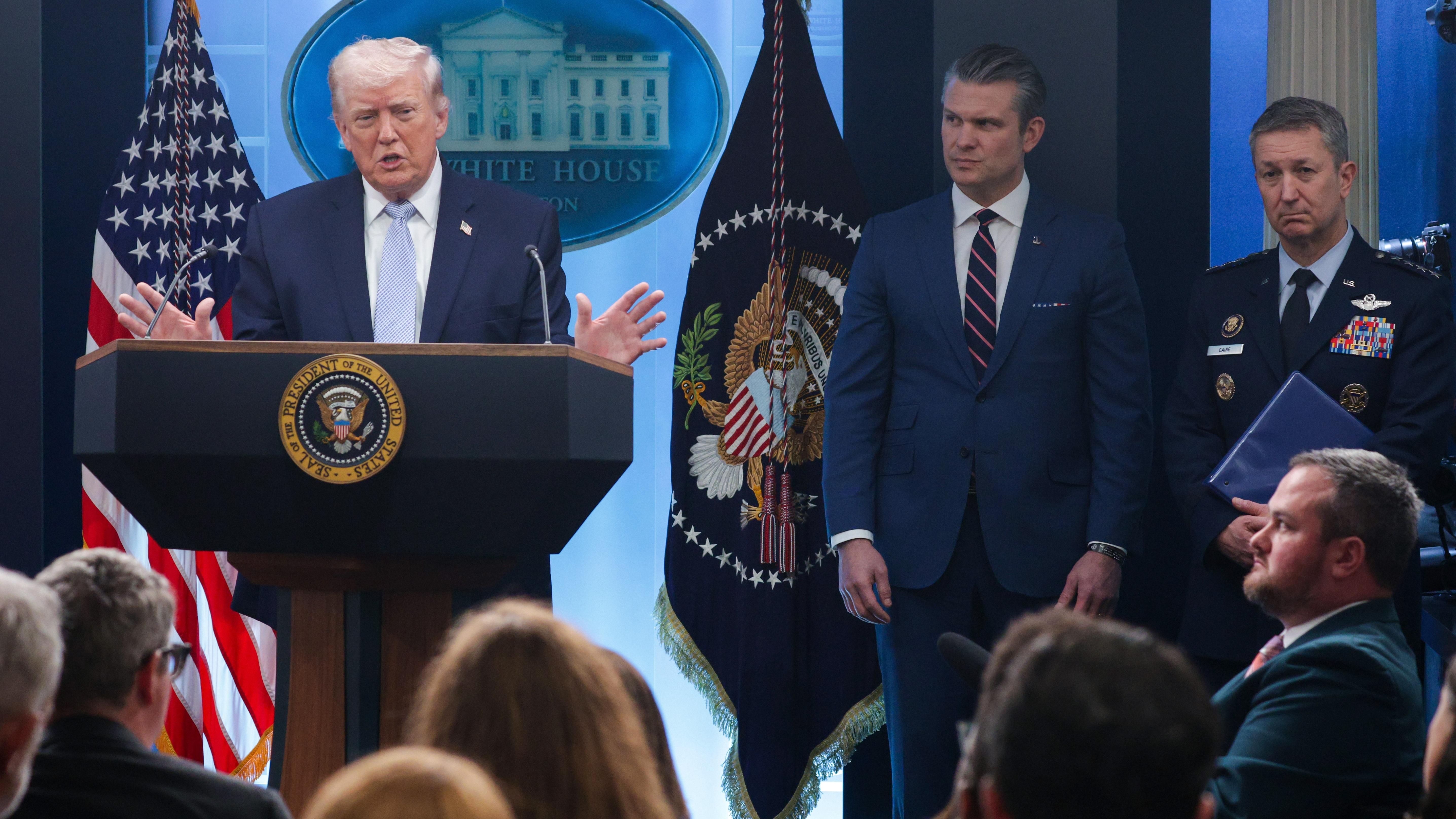 President Trump speaks as Secretary of Defense Pete Hegseth  (center) and Chairman of the Joint Chiefs of Staff General Dan Caine look on during a news conference at the White House on April 6.