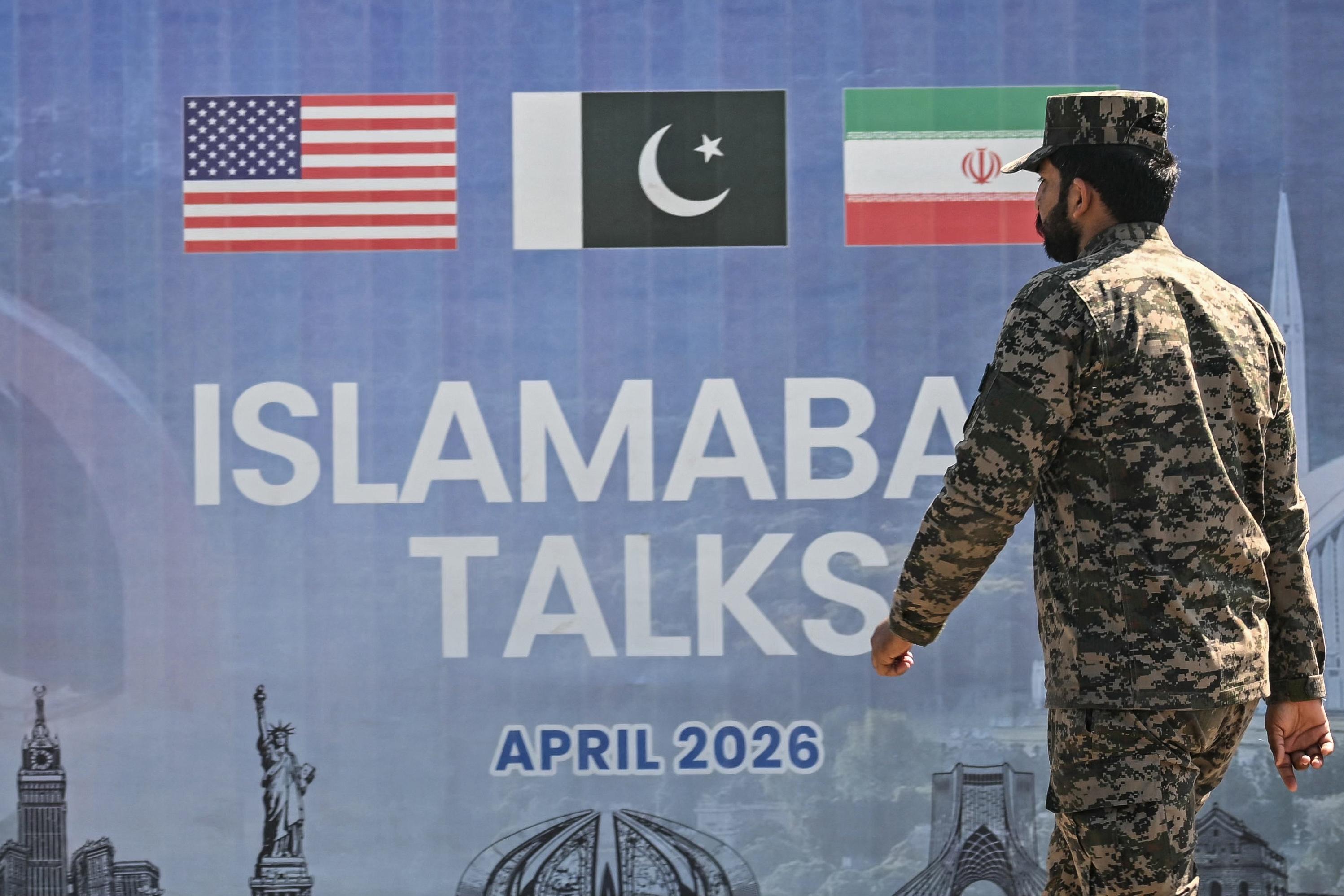 A Pakistani Ranger walks past a billboard for the U.S.-Iran peace talks in Islamabad on April 12, 2026. The talks, led by Vice President JD Vance, produced no concrete movement toward a peace deal.