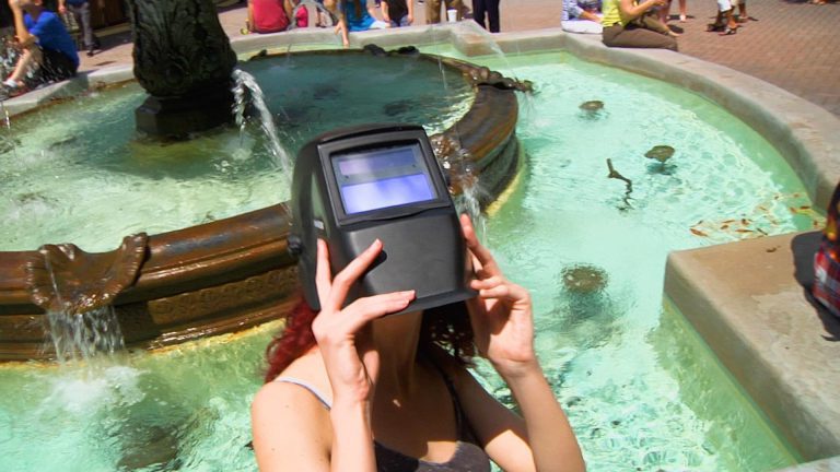 Eclipsing the Sky with the Tallahassee Astronomical Society Women looks towards sky during eclipse with a special device held to her eyes