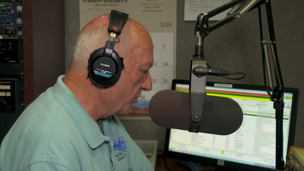Broadcaster Jim Dooley on the air at his local radio station,  W-Y-B-T in Blountstown.