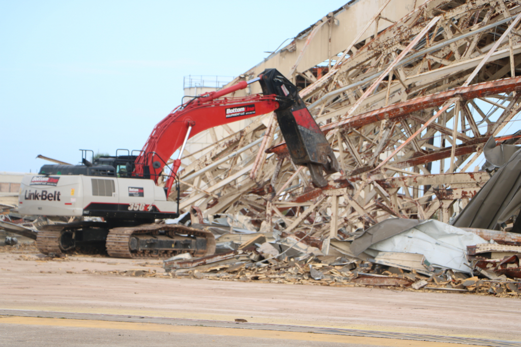 Machine moving part of a massive pile of twisted metal