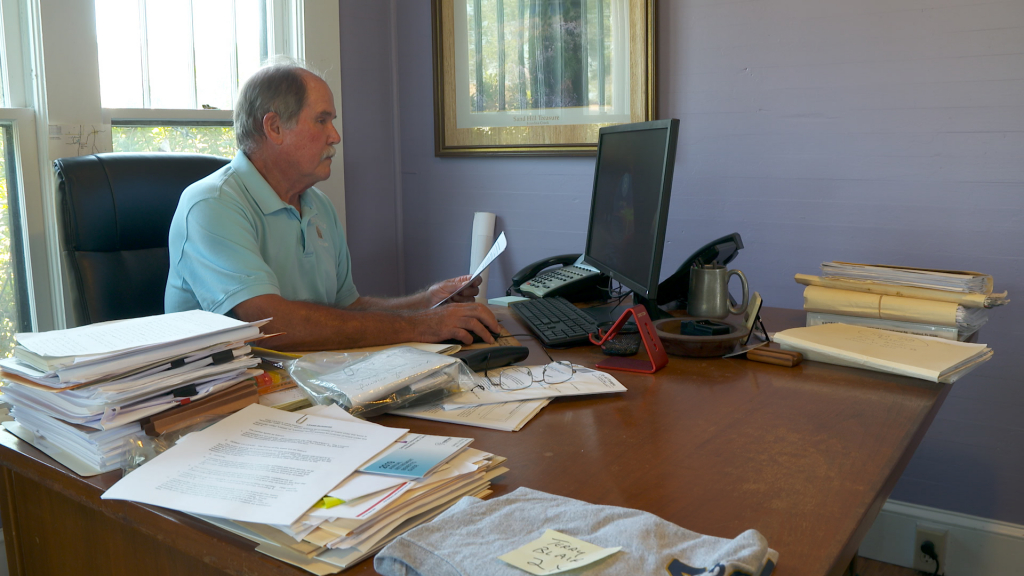 Danny Ryals sitting at a desk in his office using a computer.