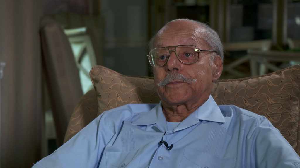 A man wearing glasses wearing a blue shirt