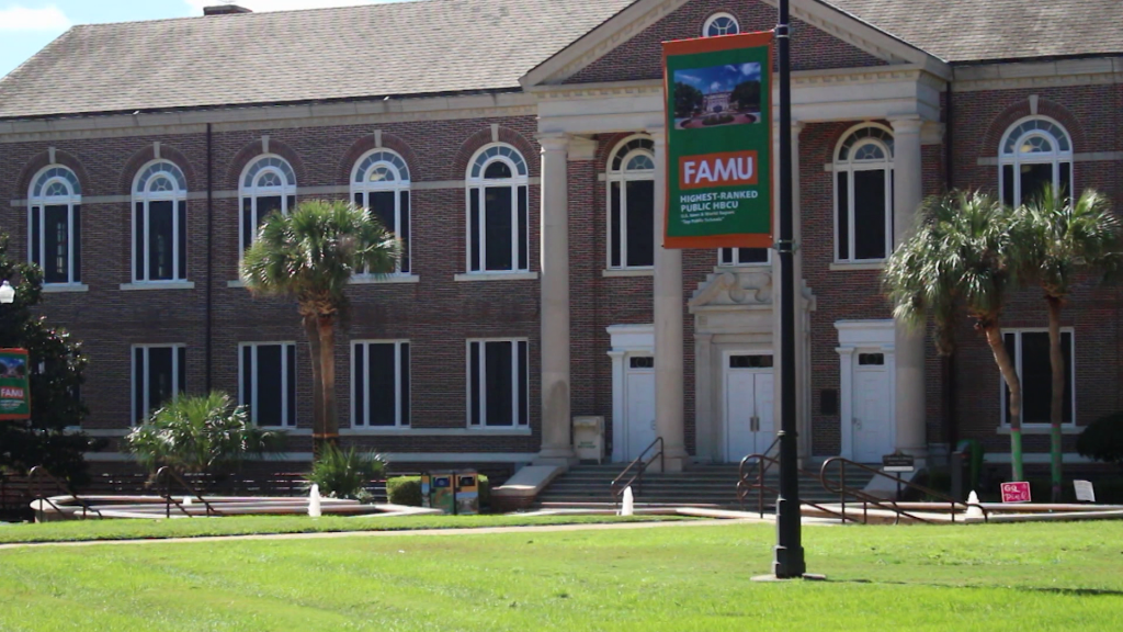 A large brick building with grass in front of a house