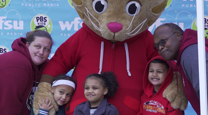 Tons of Fun at 2020 Be My Neighbor Day Lakshmi Tatma et al. standing next to a little girl posing for a picture