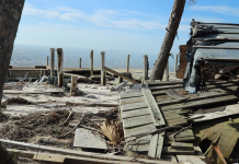 Sea Level Rise on the US 98 and Saint Vincent Island A wooden bench sitting next to a body of water