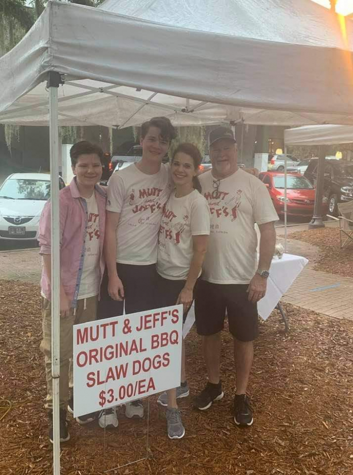 A group of people standing in front of a sign