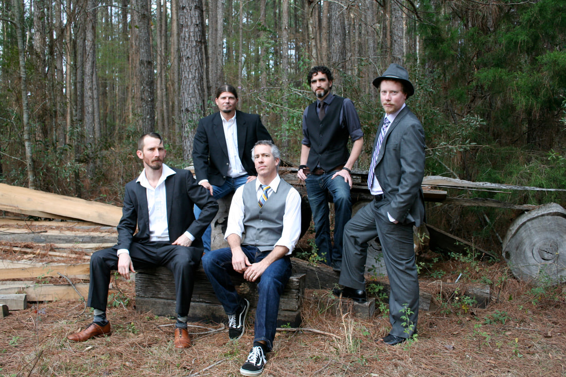 A group of people sitting on a bench next to a tree
