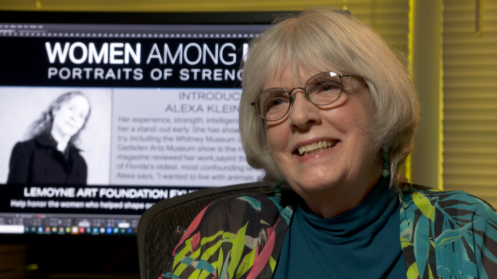 A woman wearing glasses and smiling at the camera