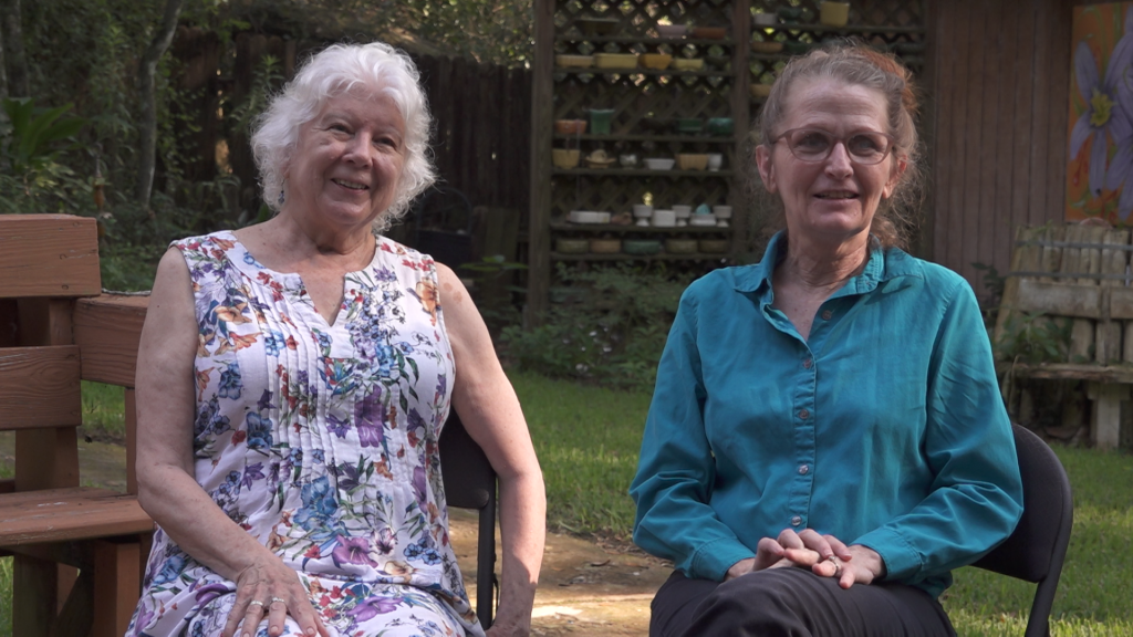 Two older women sitting on outdoors.