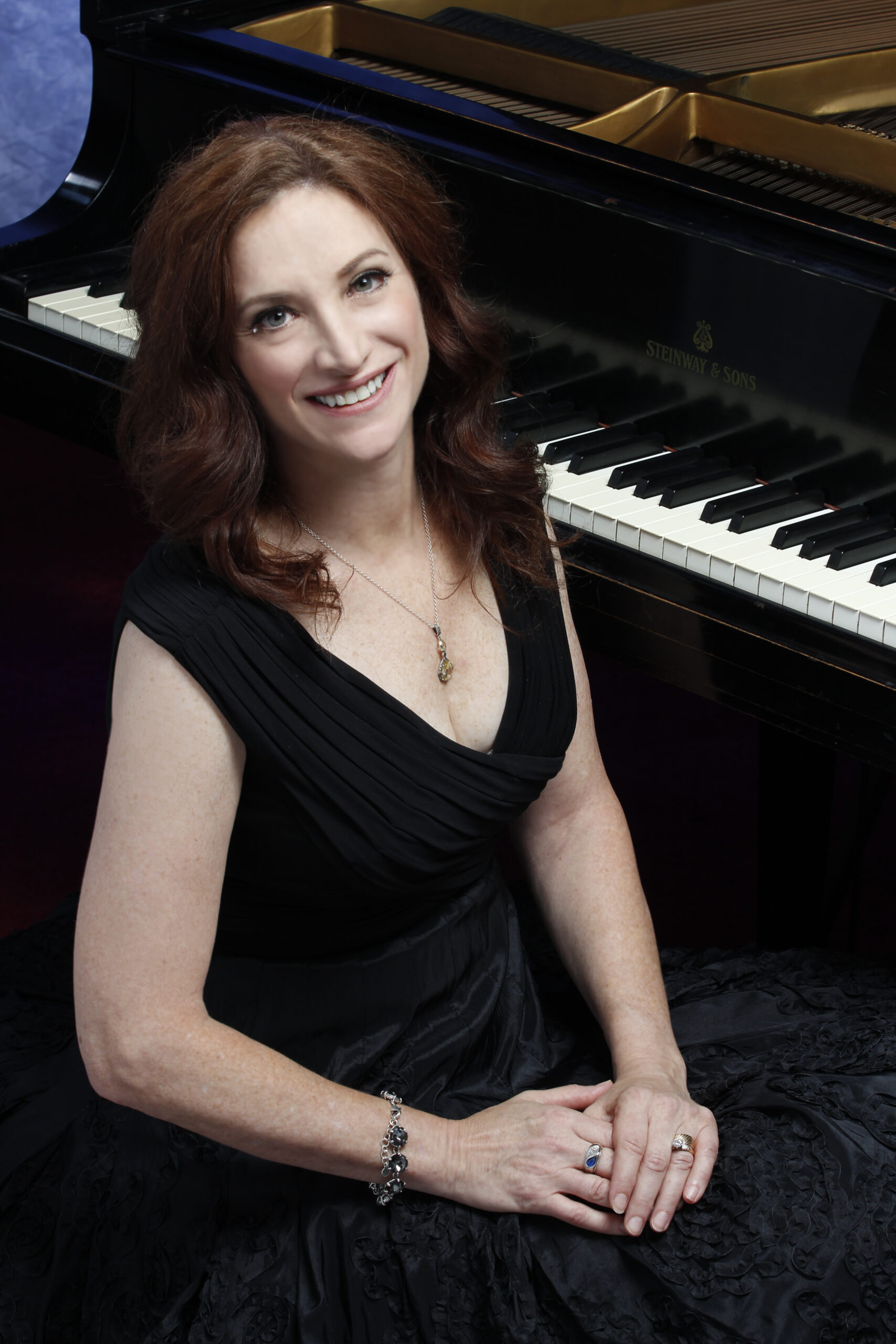 Robin Spielberg standing in front of a piano