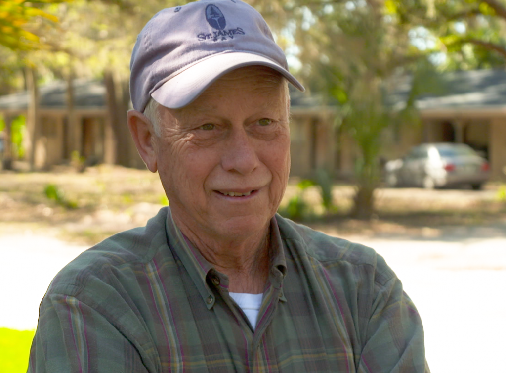 A man wearing a hat and smiling at the camera