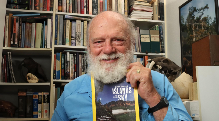 Research and Adventure in Guyana: Bruce Means Reflects A man holding a book shelf