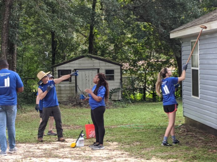 A group of people playing frisbee in a yard