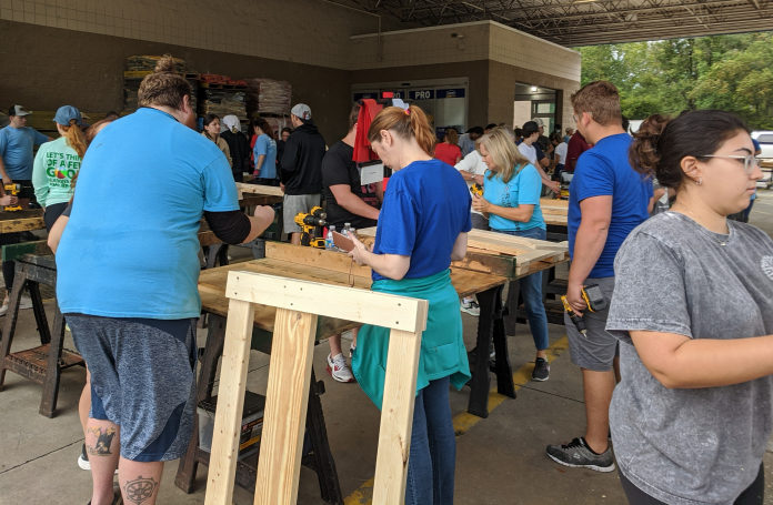 A group of people standing around a table